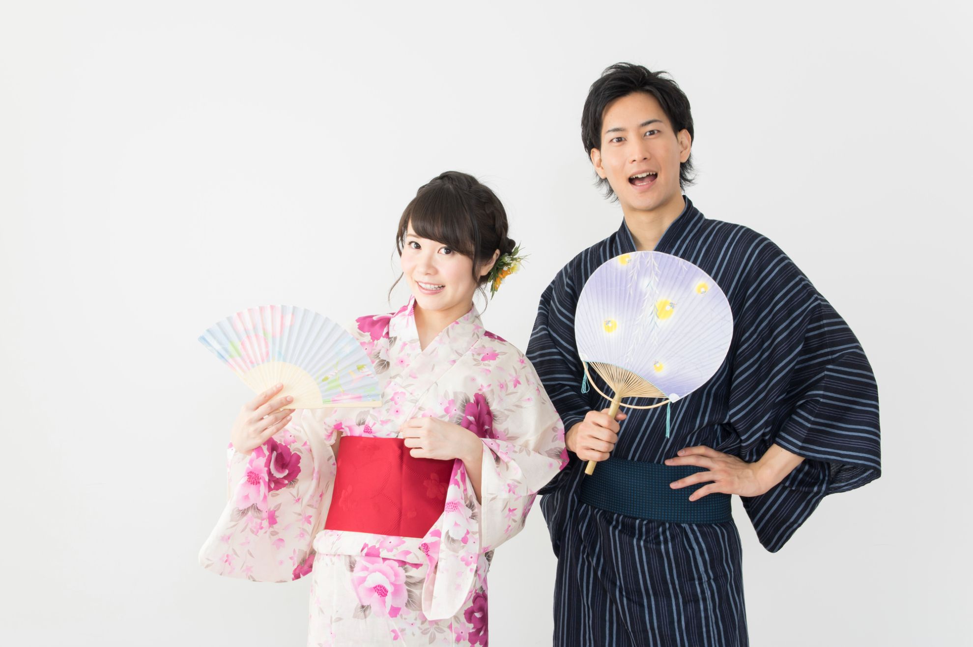 浴衣を着てうちわと扇子を持った男女